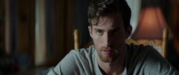 Movie still from “Cabin Fever” (2016), directed by Travis Zariwny – A person sitting in a chair; Close Up shot, Over the shoulder angle