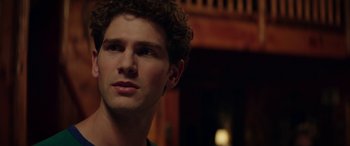 Movie still from “Cabin Fever” (2016), directed by Travis Zariwny – A person with curly brown hair; Close Up shot, Over the shoulder angle