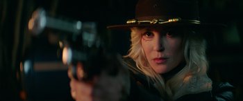 Movie still from “Cabin Fever” (2016), directed by Travis Zariwny – A woman in a hat is holding a gun; Close Up shot, Over the shoulder angle