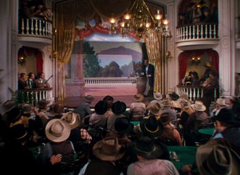 Movie still from “Calamity Jane” (1953), directed by David Butler – A crowd of people sitting in front of a stage; Extreme Wide shot, High angle
