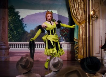 Movie still from “Calamity Jane” (1953), directed by David Butler – A woman dressed in yellow and black dancing on a stage; Wide shot, Low angle