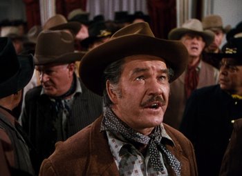 Movie still from “Calamity Jane” (1953), directed by David Butler – Many men in a line wearing hats; Medium shot, Low angle