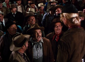 Movie still from “Calamity Jane” (1953), directed by David Butler – A group of men in cowboy hats standing next to each other; Medium shot, High angle