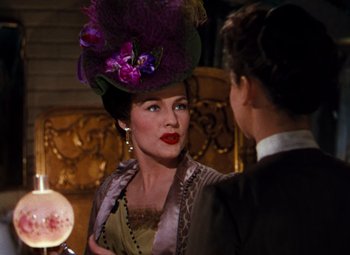 Movie still from “Calamity Jane” (1953), directed by David Butler – A woman wearing a purple hat talking to a man; Close Up shot, Over the shoulder angle