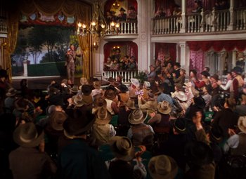 Movie still from “Calamity Jane” (1953), directed by David Butler – A group of people sitting in front of an audience wearing cowboy hats; Extreme Wide shot, High angle
