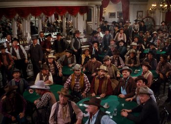 Movie still from “Calamity Jane” (1953), directed by David Butler – A group of men sitting around a table with cards; Wide shot, High angle