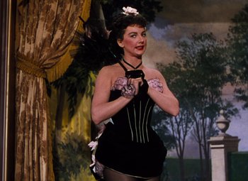 Movie still from “Calamity Jane” (1953), directed by David Butler – A woman in a black dress and a black feather headdress; Medium shot, Low angle