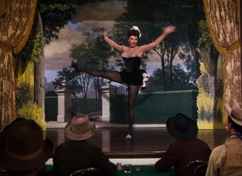 Movie still from “Calamity Jane” (1953), directed by David Butler – A woman is performing on a stage in a costume; Wide shot, Low angle