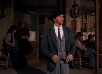 Movie still from “Calamity Jane” (1953), directed by David Butler – A man in a suit and hat holding a gun; Medium shot, Low angle