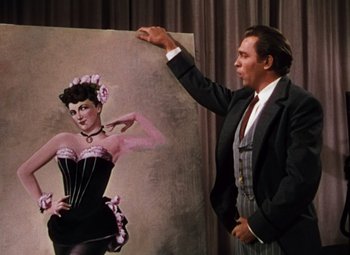 Movie still from “Calamity Jane” (1953), directed by David Butler – A man standing in front of a painting of a woman; Medium shot, Low angle