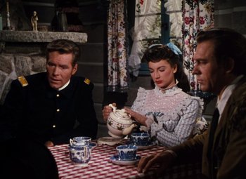 Movie still from “Calamity Jane” (1953), directed by David Butler – A group of people sitting around a table; Medium shot, High angle