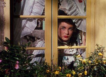 Movie still from “Calamity Jane” (1953), directed by David Butler – A woman looking out of a window with flowers in front of it; Close Up shot, Low angle