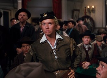 Movie still from “Calamity Jane” (1953), directed by David Butler – A man in a brown jacket and a black hat; Medium shot, Over the shoulder angle