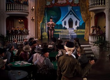 Movie still from “Calamity Jane” (1953), directed by David Butler – A group of people sitting in front of a screen; Wide shot, Low angle