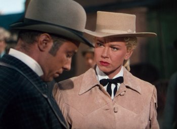 Movie still from “Calamity Jane” (1953), directed by David Butler – A man and a woman wearing hats and coats; Medium shot, Over the shoulder angle