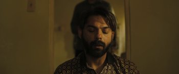 Movie still from “Camp X-Ray” (2014), directed by Peter Sattler – A man with his eyes closed in front of a mirror; Close Up shot, Over the shoulder angle