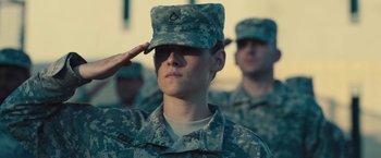Movie still from “Camp X-Ray” (2014), directed by Peter Sattler – A soldier saluting while another soldier is saluting; Medium shot, Low angle