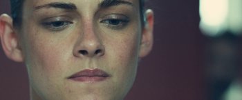 Movie still from “Camp X-Ray” (2014), directed by Peter Sattler – A woman's face with a brown background; Extreme Close Up shot, Low angle