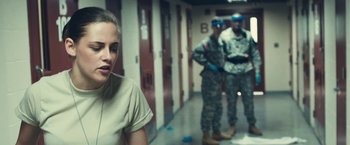 Movie still from “Camp X-Ray” (2014), directed by Peter Sattler – A group of soldiers standing next to each other in a hallway; Medium shot, Over the shoulder angle