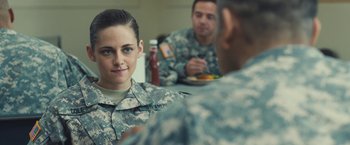 Movie still from “Camp X-Ray” (2014), directed by Peter Sattler – A woman in military fatigues sitting at a table with two other men in fatigues; Close Up shot, Over the shoulder angle