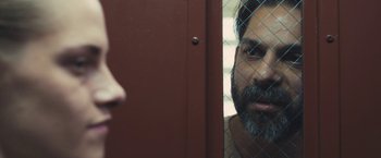 Movie still from “Camp X-Ray” (2014), directed by Peter Sattler – A man with a beard looking into a mirror; Close Up shot, Over the shoulder angle