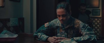 Movie still from “Camp X-Ray” (2014), directed by Peter Sattler – A woman in a military fatigues looking at her cell phone; Medium shot, Over the shoulder angle