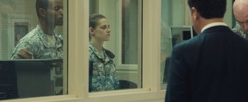 Movie still from “Camp X-Ray” (2014), directed by Peter Sattler – A woman in military fatigues looking out of a window; Medium shot, Over the shoulder angle