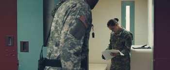 Movie still from “Camp X-Ray” (2014), directed by Peter Sattler – A soldier and a woman in uniform looking at papers in a room; Medium shot, Over the shoulder angle