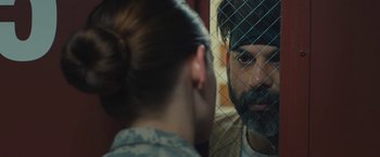 Movie still from “Camp X-Ray” (2014), directed by Peter Sattler – A man and a woman talking in front of a fence; Close Up shot, Over the shoulder angle