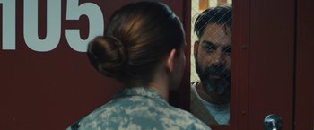 Movie still from “Camp X-Ray” (2014), directed by Peter Sattler – A woman in a military uniform looking at a man in the mirror; Close Up shot, Over the shoulder angle