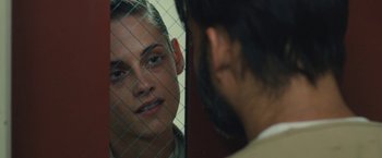 Movie still from “Camp X-Ray” (2014), directed by Peter Sattler – A man and a woman looking at each other through a fence; Close Up shot, Over the shoulder angle