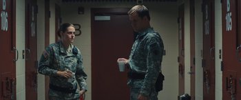 Movie still from “Camp X-Ray” (2014), directed by Peter Sattler – A man and a woman in military fatigues drinking coffee; Medium shot, Over the shoulder angle