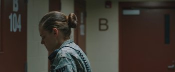 Movie still from “Camp X-Ray” (2014), directed by Peter Sattler – A woman in military fatigues is standing next to a wall; Medium shot, Over the shoulder angle