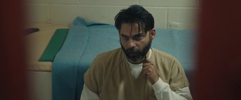 Movie still from “Camp X-Ray” (2014), directed by Peter Sattler – A man with a long beard is sitting on a bed; Close Up shot, Over the shoulder angle