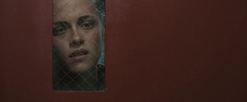 Movie still from “Camp X-Ray” (2014), directed by Peter Sattler – A woman looking through a chain link fence; Close Up shot, Low angle
