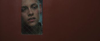 Movie still from “Camp X-Ray” (2014), directed by Peter Sattler – A woman looking out a window through a wire fence; Close Up shot, Over the shoulder angle
