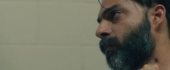 Movie still from “Camp X-Ray” (2014), directed by Peter Sattler – A person with a beard; Close Up shot, Over the shoulder angle
