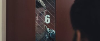 Movie still from “Camp X-Ray” (2014), directed by Peter Sattler – A man in a military uniform looking through a fence; Close Up shot, Over the shoulder angle