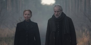 Movie still from “Dark” (2017), created by Baran bo Odar – A man and a woman standing next to each other in the fog; Medium shot, Low angle