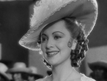 Movie still from “Captain Blood” (1935), directed by Michael Curtiz – A black and white photo of a woman wearing a hat; Close Up shot, High angle