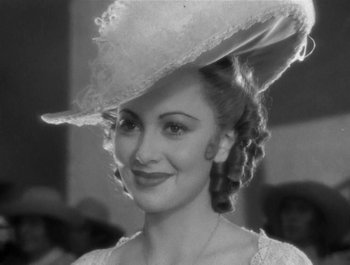 Movie still from “Captain Blood” (1935), directed by Michael Curtiz – A black and white photo of a woman wearing a hat; Close Up shot, Over the shoulder angle