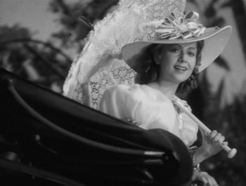 Movie still from “Captain Blood” (1935), directed by Michael Curtiz – A woman with a hat and a parasol in a carriage; Medium shot, Low angle