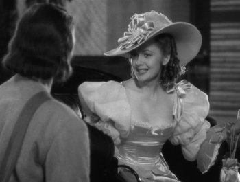 Movie still from “Captain Blood” (1935), directed by Michael Curtiz – A black and white photo of a woman wearing a hat; Medium shot, Over the shoulder angle