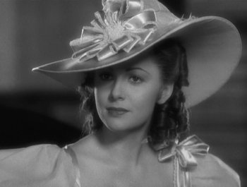 Movie still from “Captain Blood” (1935), directed by Michael Curtiz – A black and white photo of a woman wearing a hat; Close Up shot, Low angle