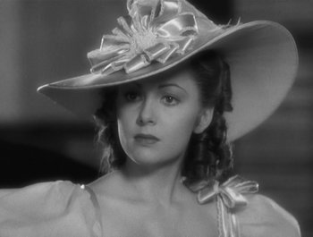 Movie still from “Captain Blood” (1935), directed by Michael Curtiz – A black and white photo of a woman wearing a hat; Close Up shot, Low angle