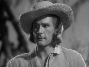 Movie still from “Captain Blood” (1935), directed by Michael Curtiz – A black and white photo of a man wearing a cowboy hat; Close Up shot, Low angle