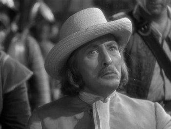 Movie still from “Captain Blood” (1935), directed by Michael Curtiz – A man in a hat looking to his left; Close Up shot, Over the shoulder angle