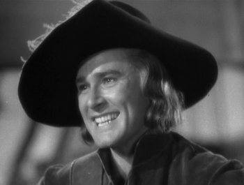 Movie still from “Captain Blood” (1935), directed by Michael Curtiz – A black and white photo of a man wearing a cowboy hat; Close Up shot, Low angle