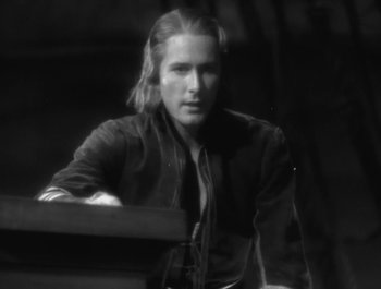 Movie still from “Captain Blood” (1935), directed by Michael Curtiz – Black and white photograph of a man with long blonde hair; Close Up shot, High angle
