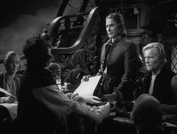 Movie still from “Captain Blood” (1935), directed by Michael Curtiz – A black - and - white photo of a man and a woman; Medium shot, Over the shoulder angle